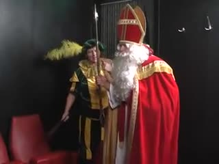 Sinterklaas Faust fickt einer seiner Hilfer  in dem Paket-Boot